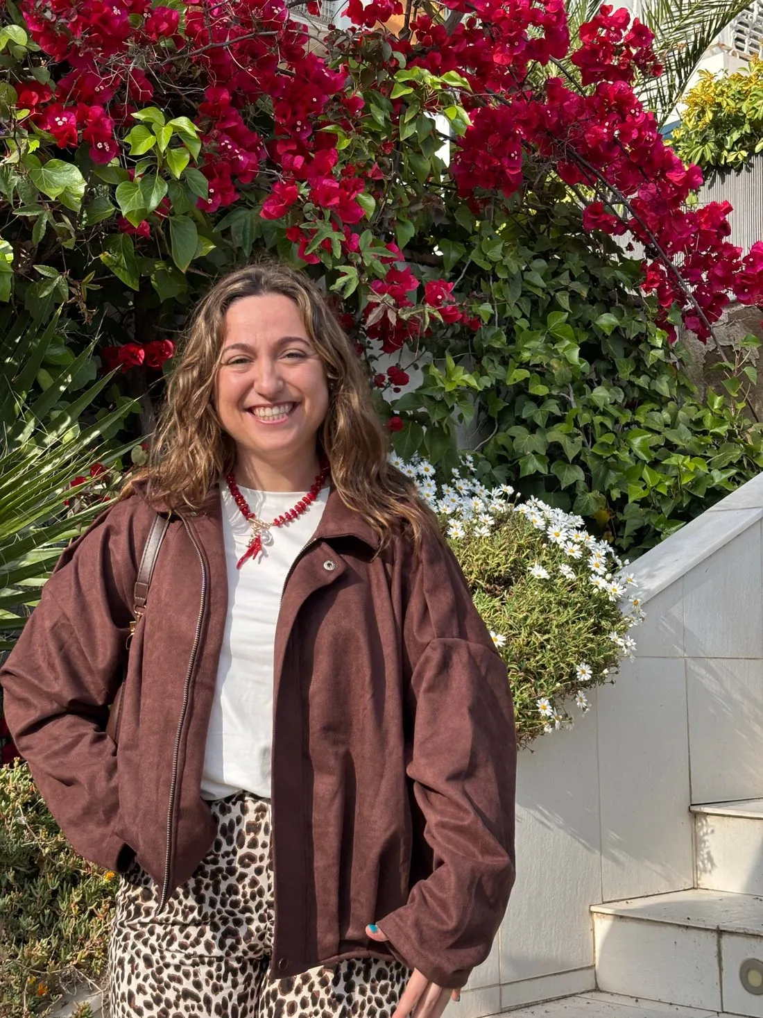 Eneka sonriendo delante de una buganvilla en flor